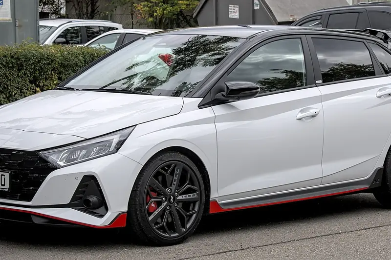 White Hyundai i20 hatchback with red accents, front three-quarter view