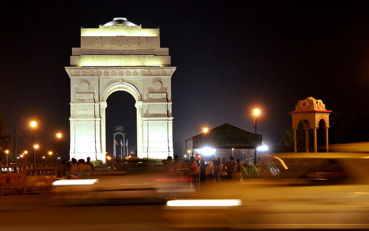 India Gate lit up at night with light trails from passing traffic